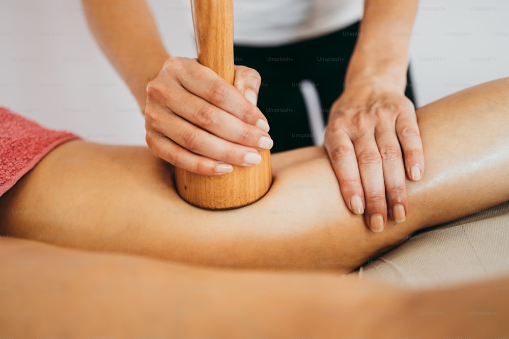Femme d’âge moyen au traitement professionnel de massage de madérothérapie anti-cellulite. Plan rapproché.