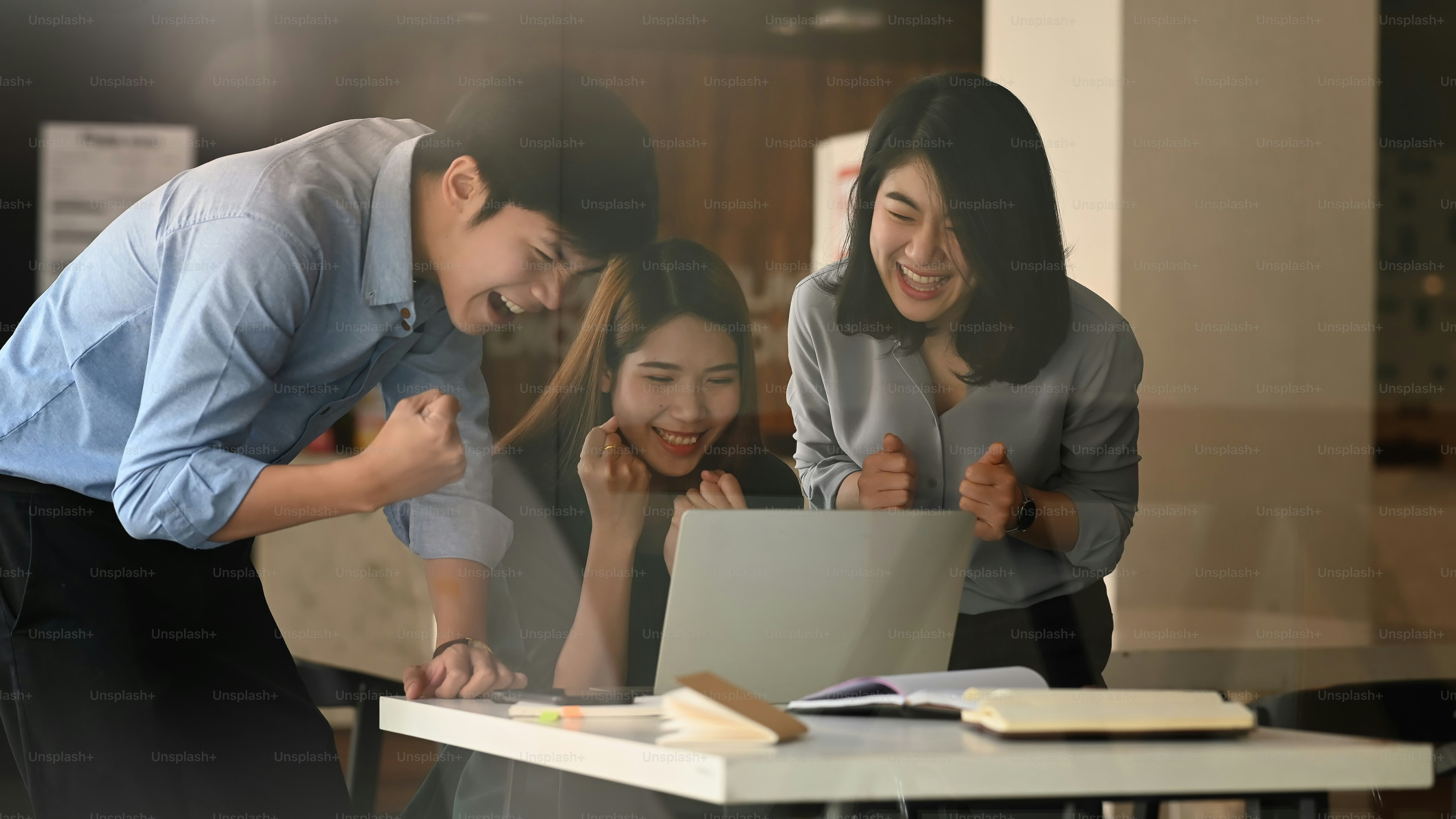 Photo of young business development team talking/discussing/brainstorming/meeting/planning about them new business project result at the meeting table with modern office/meeting room as background.