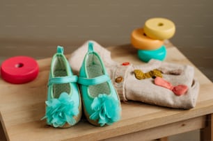 Baby girl shoes nd clothing on the kids chair in children room. Selective focus.
