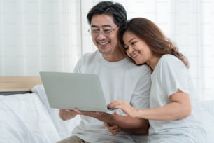 Happy Asian senior couple having good time at home. Old people retirement and healthy citizens elderly concept.