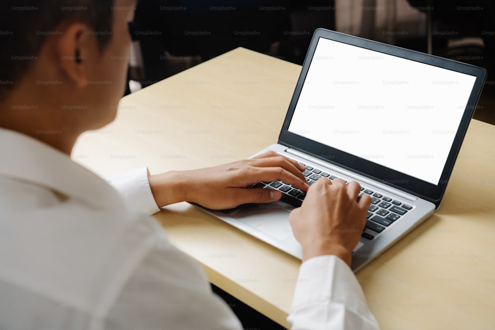 Business person or office worker using laptop computer while sitting at desk.