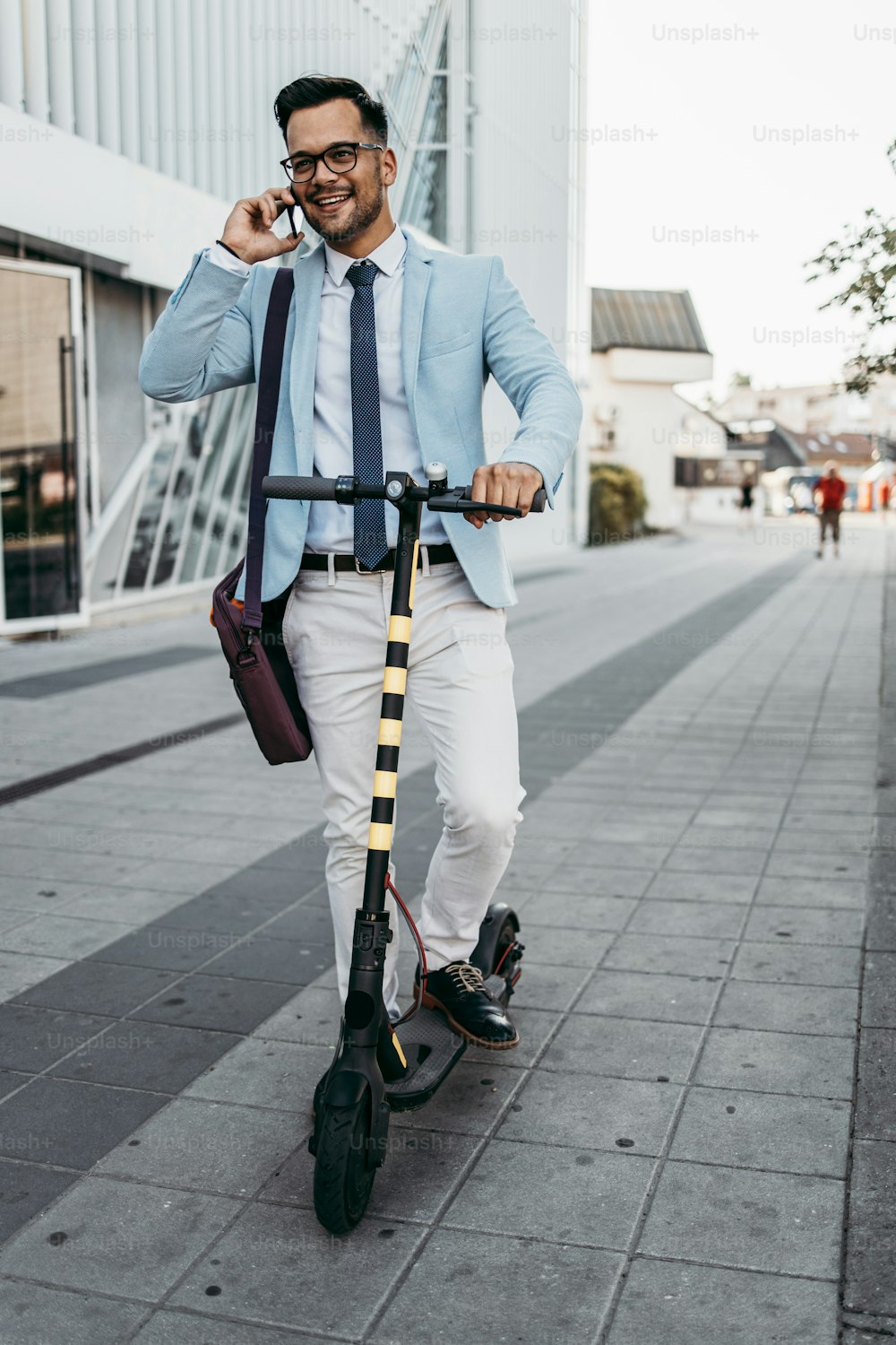 Jovem homem moderno usando e dirigindo scooter elétrico na rua da cidade. Conceito de transporte moderno e ecológico.