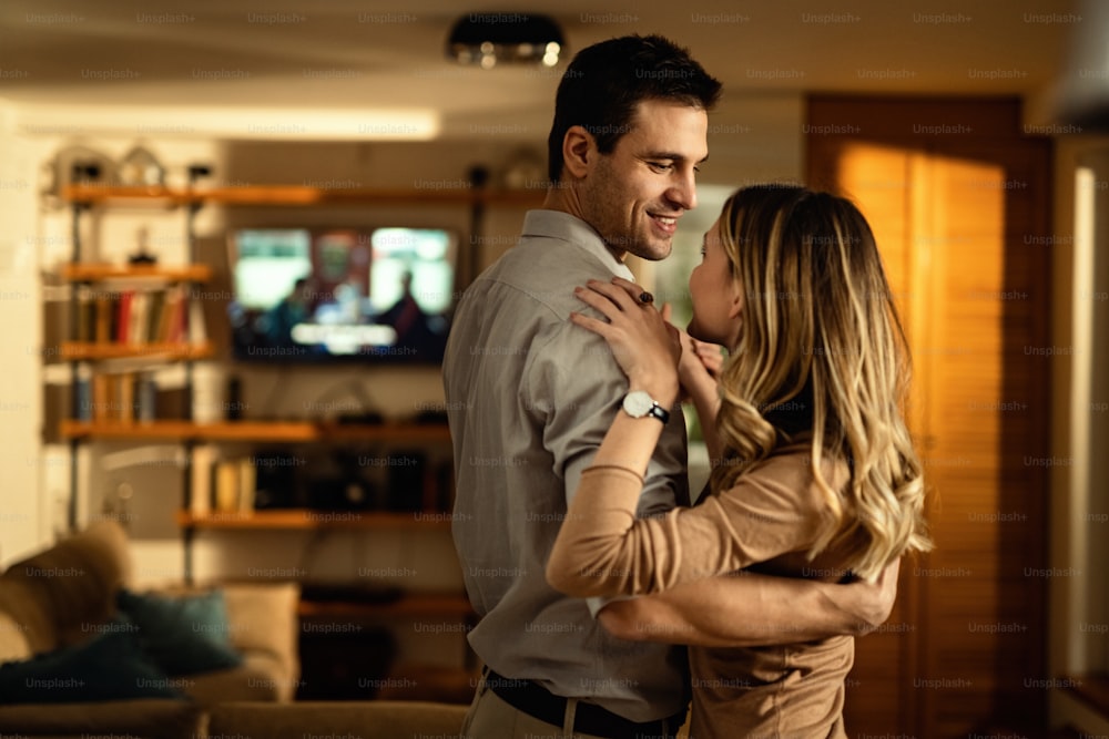 Jeune couple heureux amoureux dansant à la maison.