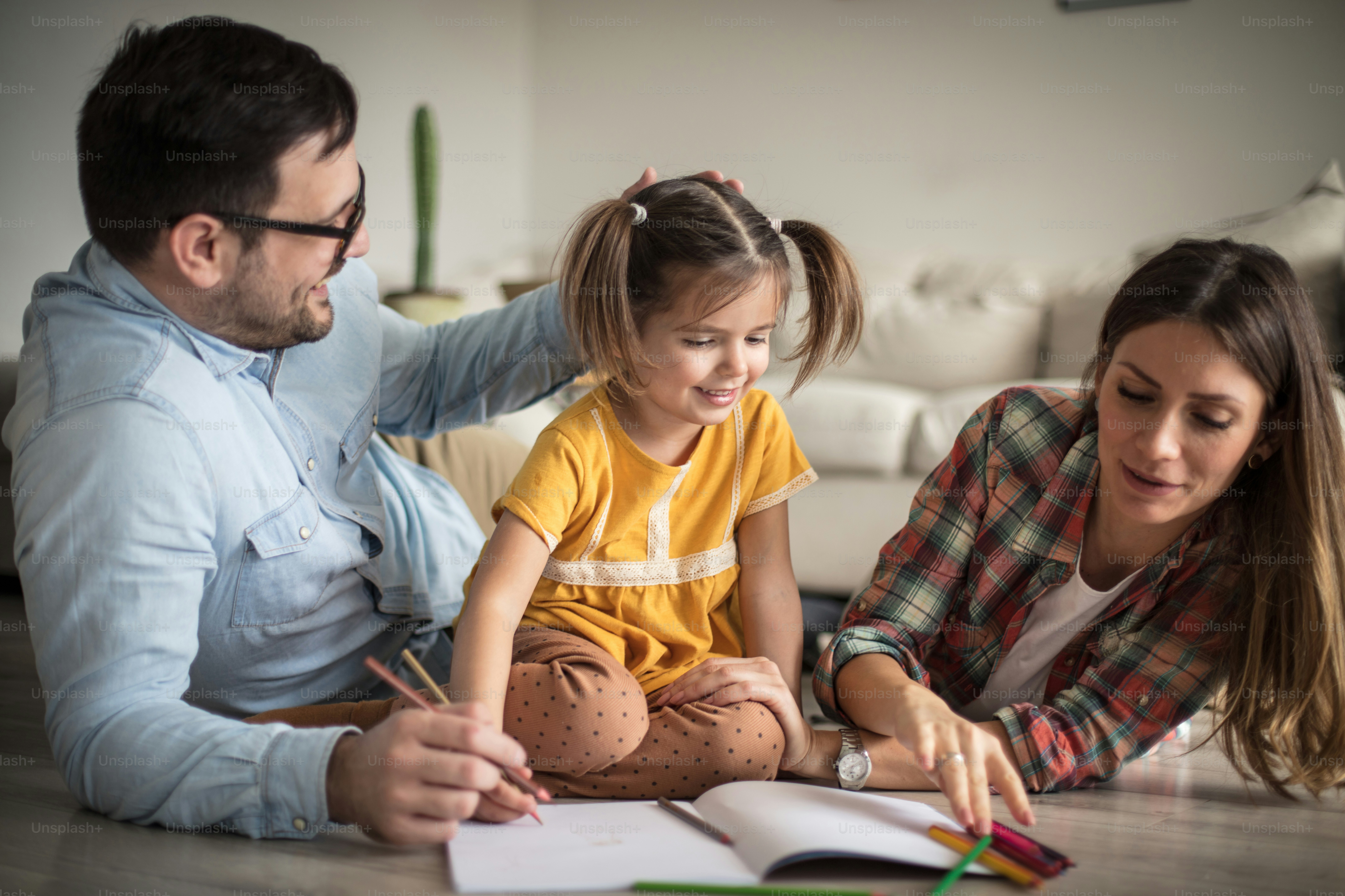 Parents supporting their child while studying together at a home table