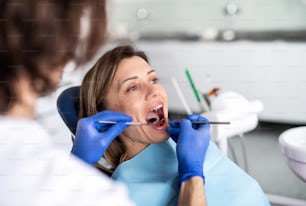 A woman has an annual dental check-up in dentist surgery.