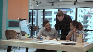 Kreative Geschäftsleute, die sich am Schreibtisch an einem modernen Arbeitsplatz unterhalten. Internationales Geschäftskonzept des Unternehmens.