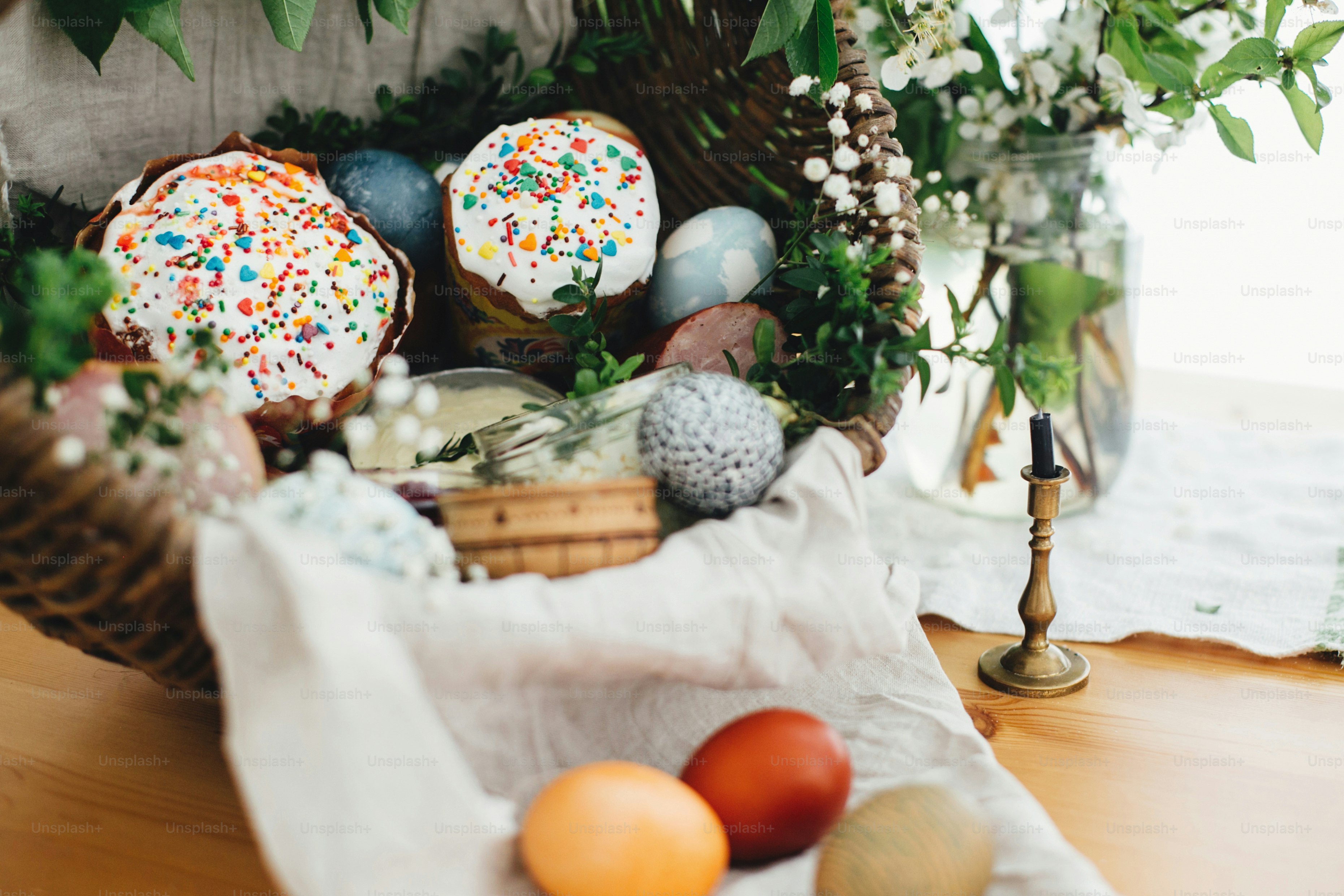 Easter modern eggs, easter bread, ham, beets, butter, sausages in rustic basket decorated with
