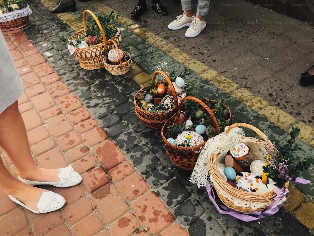 Comida tradicional ortodoxa de Pascua para la bendición. Cestas de Pascua con elegantes huevos pintados, pastel de Pascua, jamón, mantequilla, vela con ramas de boj para santificar en la iglesia