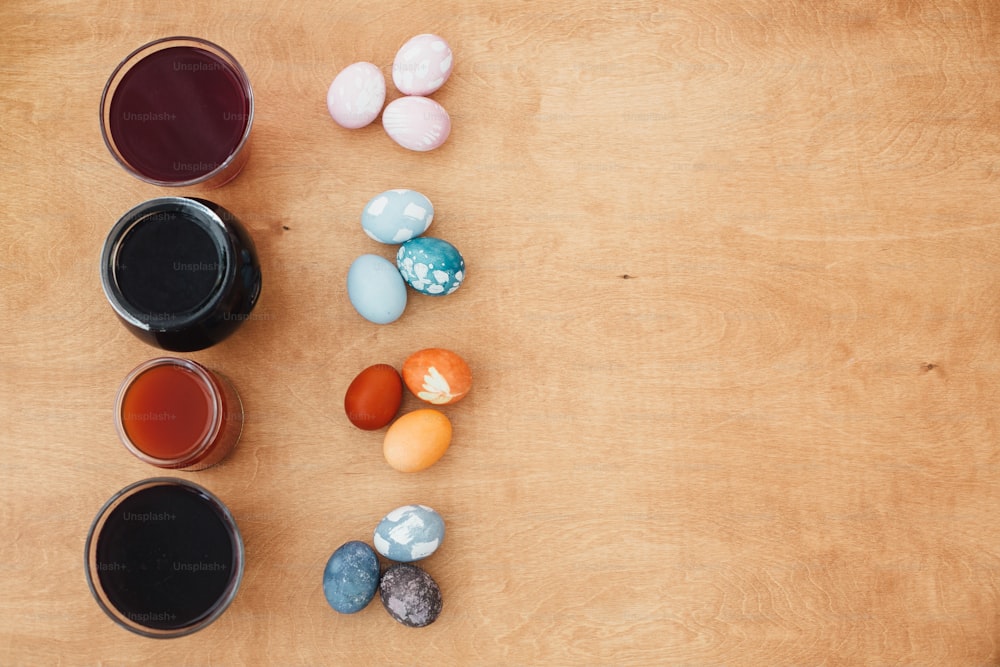 Uova di Pasqua coloranti naturali su tavolo di legno con spazio di copia. Uova rosa - con barbabietola, turchese - cavolo rosso, arancione e giallo - cipolla o curcuma, grigio e viola - tè carcade. Zero sprechi