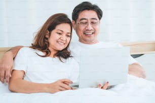 Happy Asian senior couple having good time at home. Old people retirement and healthy citizens elderly concept.