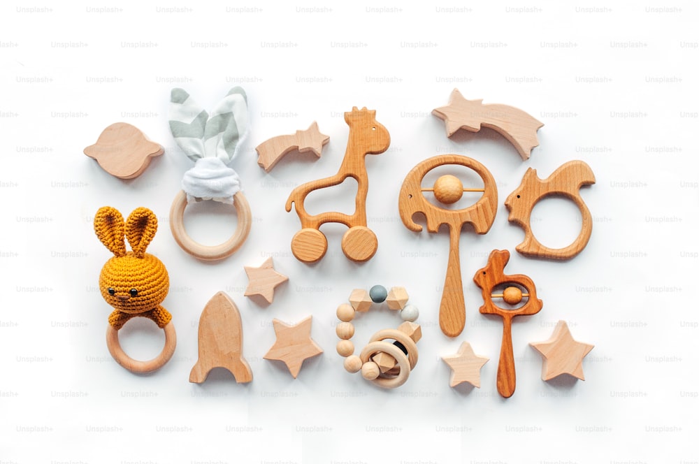 Eco friendly non plastic toys concept. Baby background. Wooden toys and teethers on white background with blank space for text.