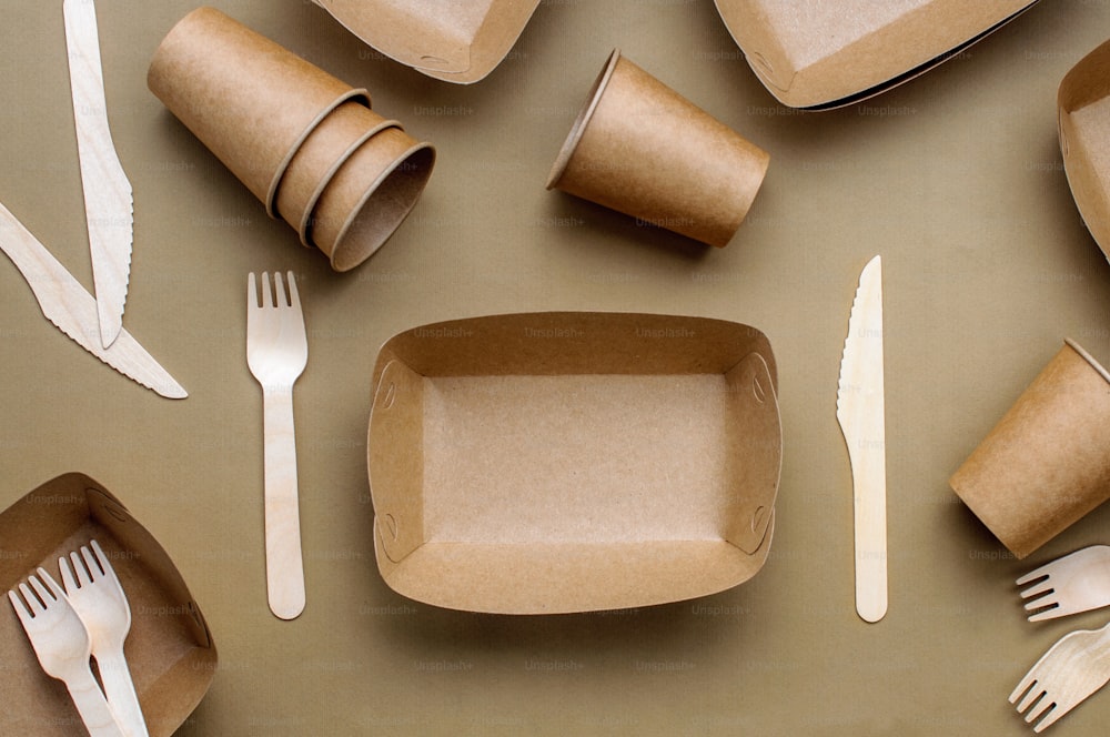 Disposable eco friendly food packaging. Brown kraft paper food containers on beige background. Top view, flat lay.