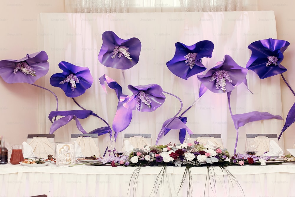 big purple flowers at wedding centerpiece for bride groom setting in restaurant, luxury wedding reception, stylish decor