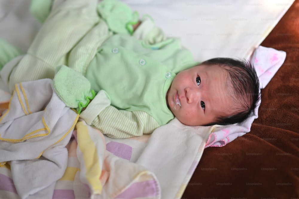 Top view image of adorable newborn baby lying/relaxing on comfortable diaper bed. Newborn baby slept after the mother has finished feeding concept.