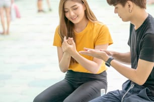 Young Asian man and woman using alcohol gel washing their hands and fingers