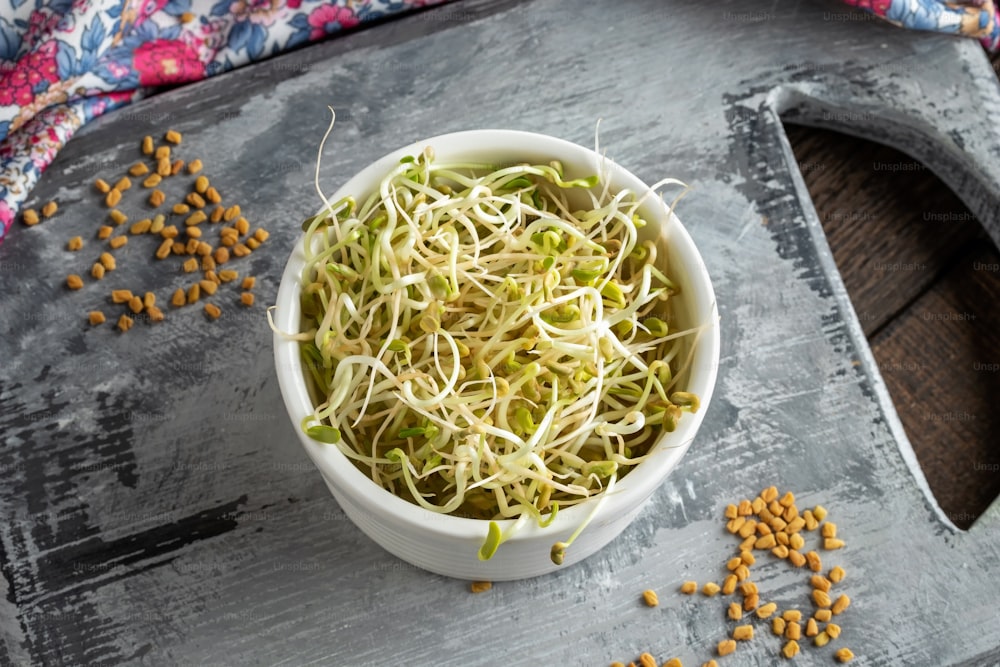 Fresh fenugreek sprouts in a white bowl