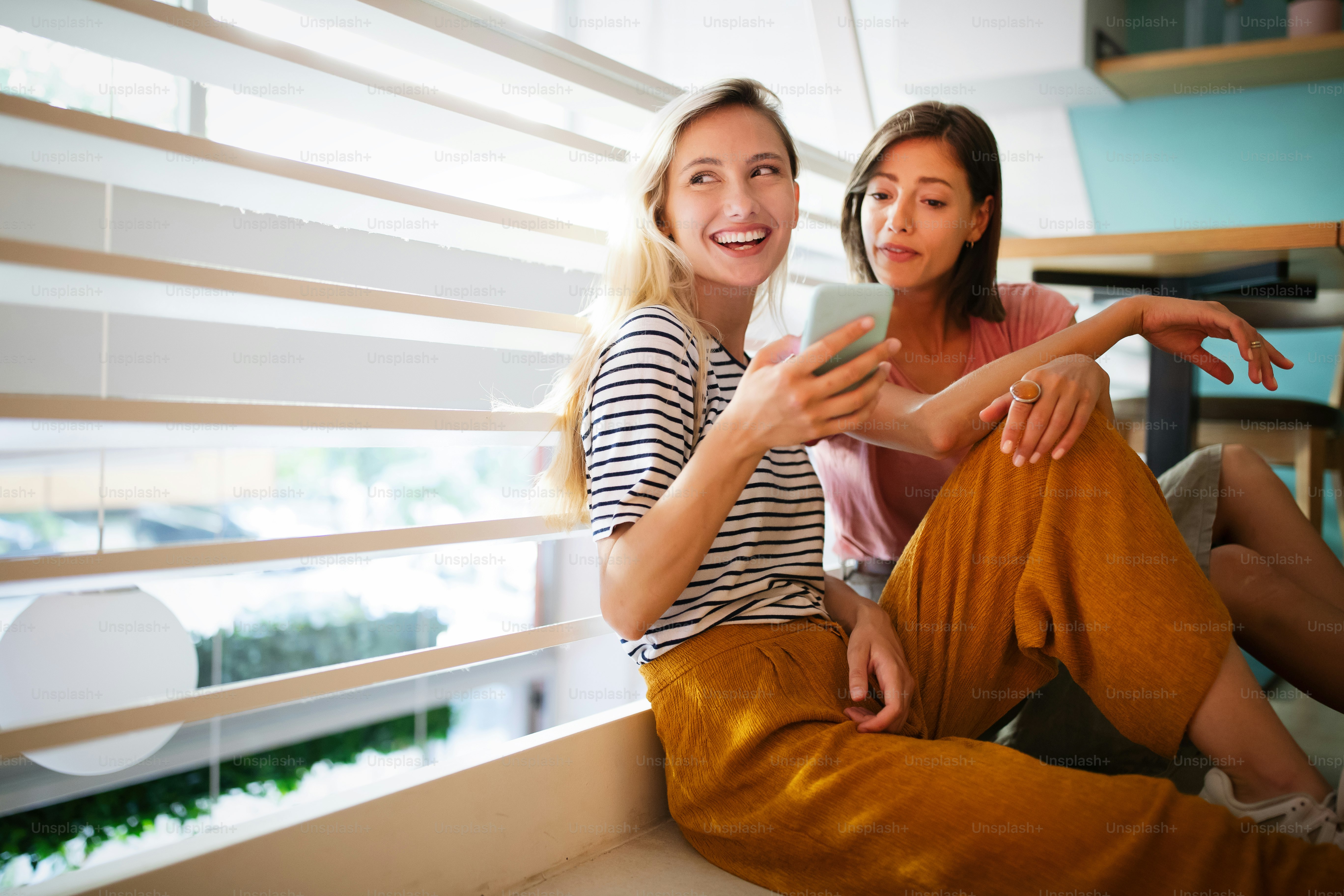 若い女性の友達がネットサーフィンをして一緒に楽しんでいる