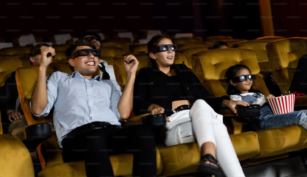 Grupo de pessoas assiste a filmes com óculos 3D no cinema com interesse olhando para a tela, emocionante e desfrutar