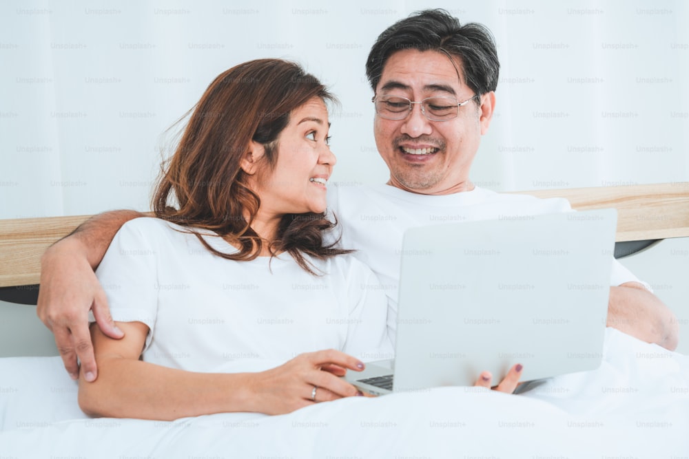 Happy Asian senior couple having good time at home. Old people retirement and healthy citizens elderly concept.