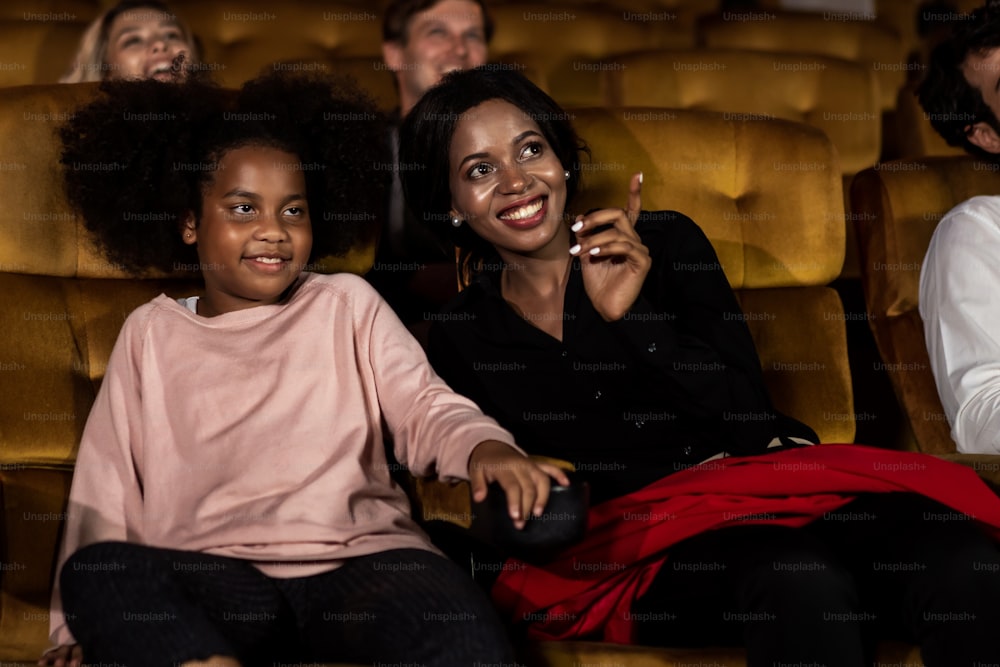 Frau genießt es, einen Film mit ihrer Tochter im Kino zu sehen, lächelt und lacht zusammen