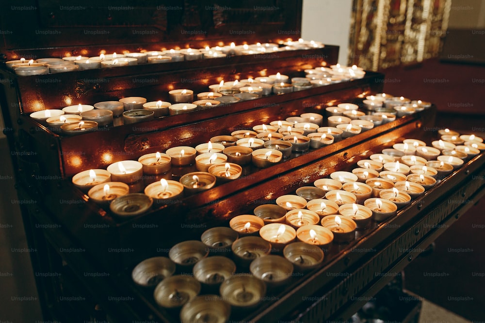 Brûler des bougies sur l’autel en gros plan dans l’église, allumer une bougie, pleurer les victimes dans les attaques terroristes et les révolutions, moment de tristesse. Concept de funérailles, de foi et de mémoire