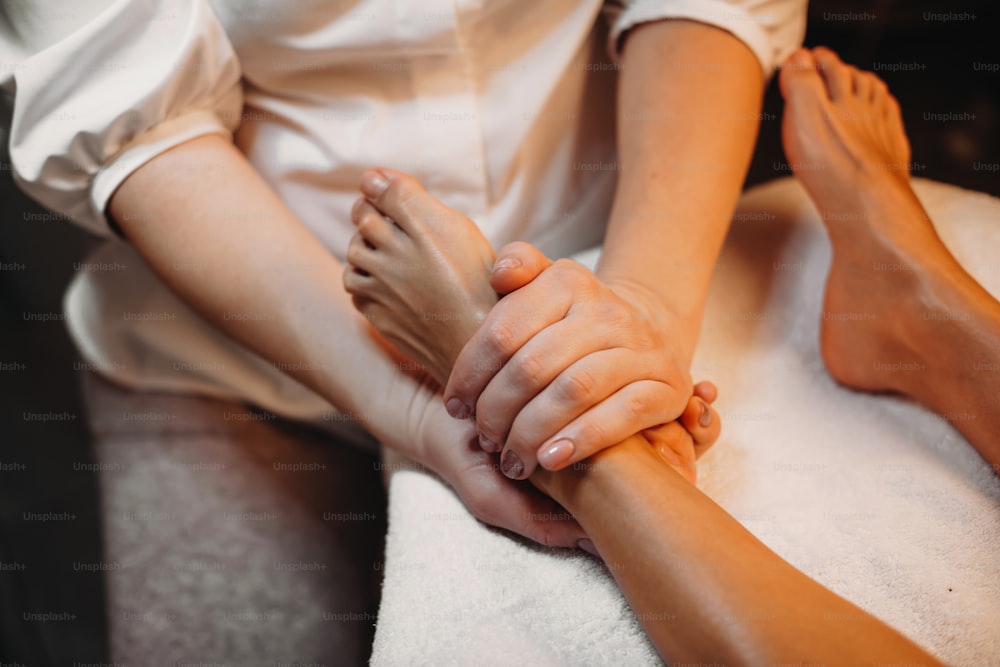 Kaukasisches Mädchen mit Anti-Aging-Massage für ihre Beinhaut während einer Spa-Behandlung