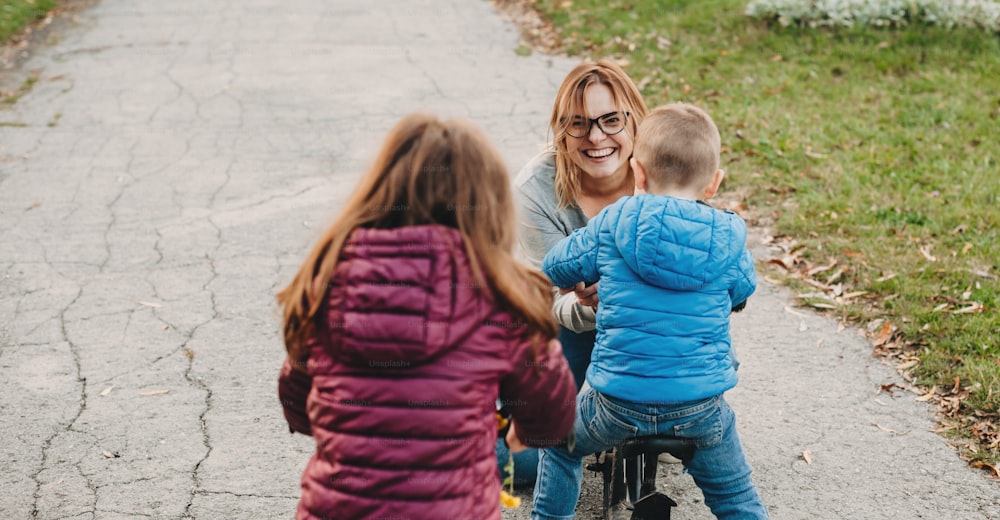 Una madre caucásica con anteojos anima a sus hijos durante una excursión familiar