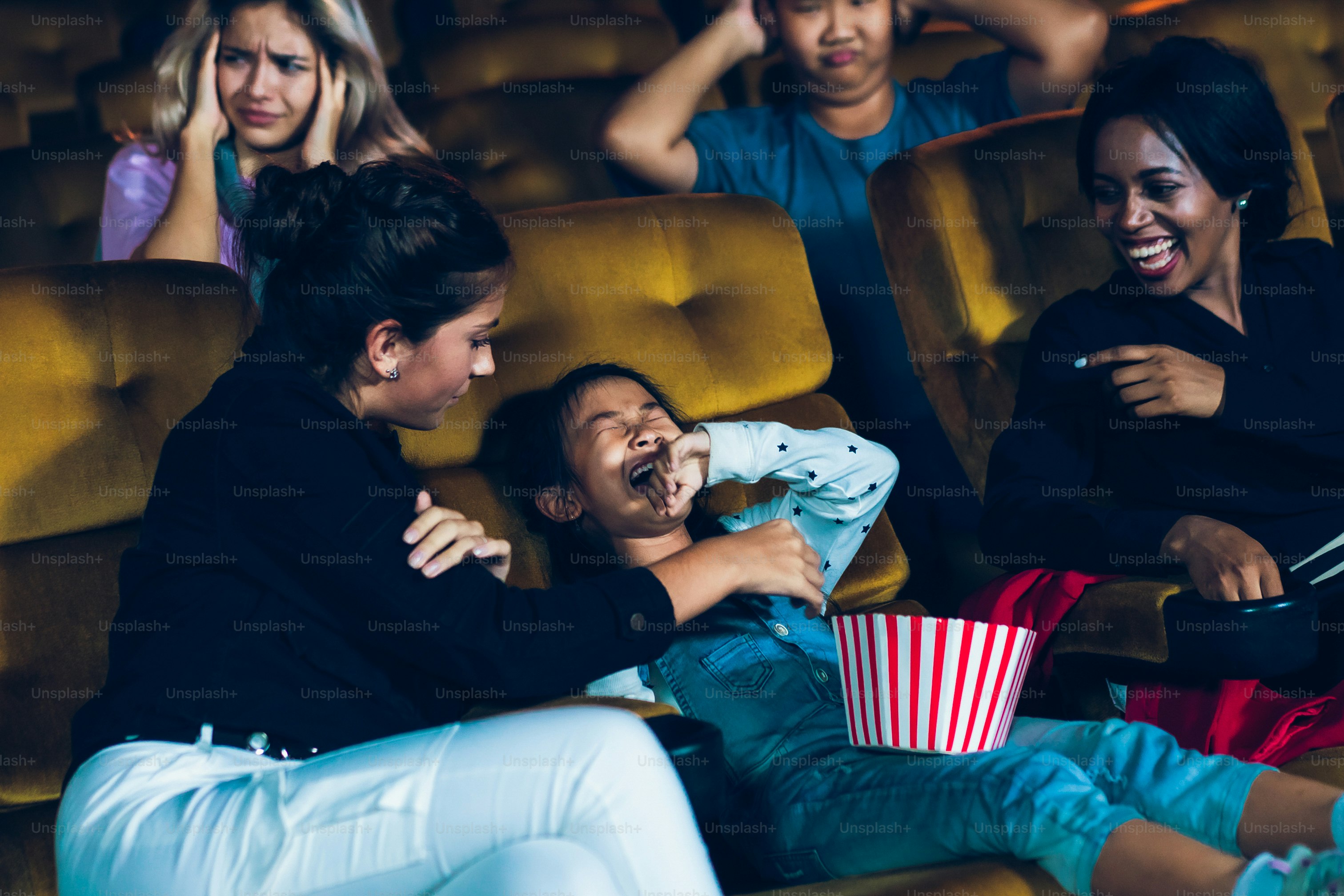 The girls cried loudly in the cinema, causing annoyance to the people sitting next to and behind them