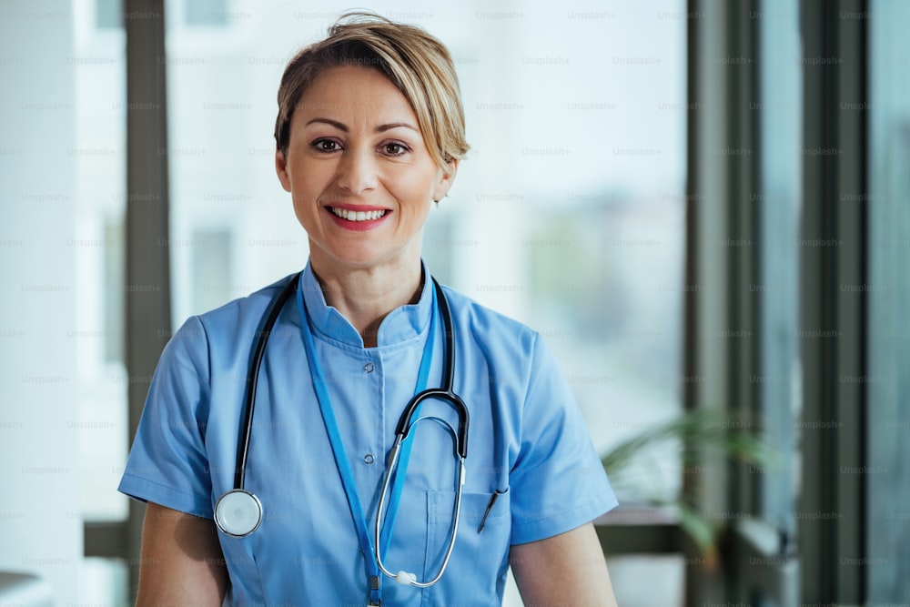 Portrait of smiling nurse looking at camera while standing at clinic.