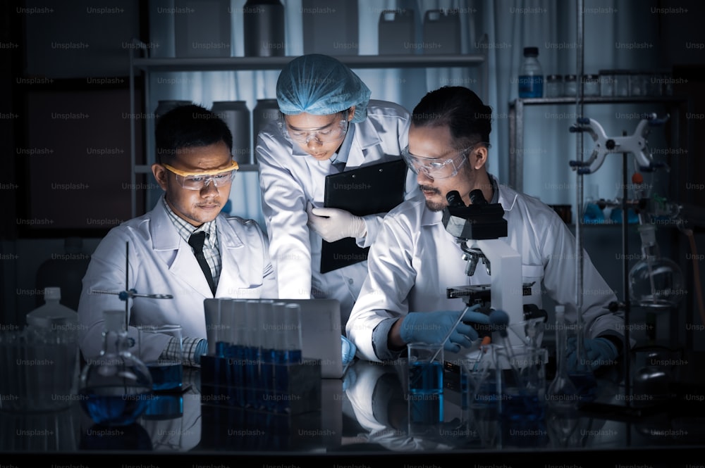 In un laboratorio moderno il team di scienziati conduce esperimenti, costituiti da provette e microscopi di vetreria