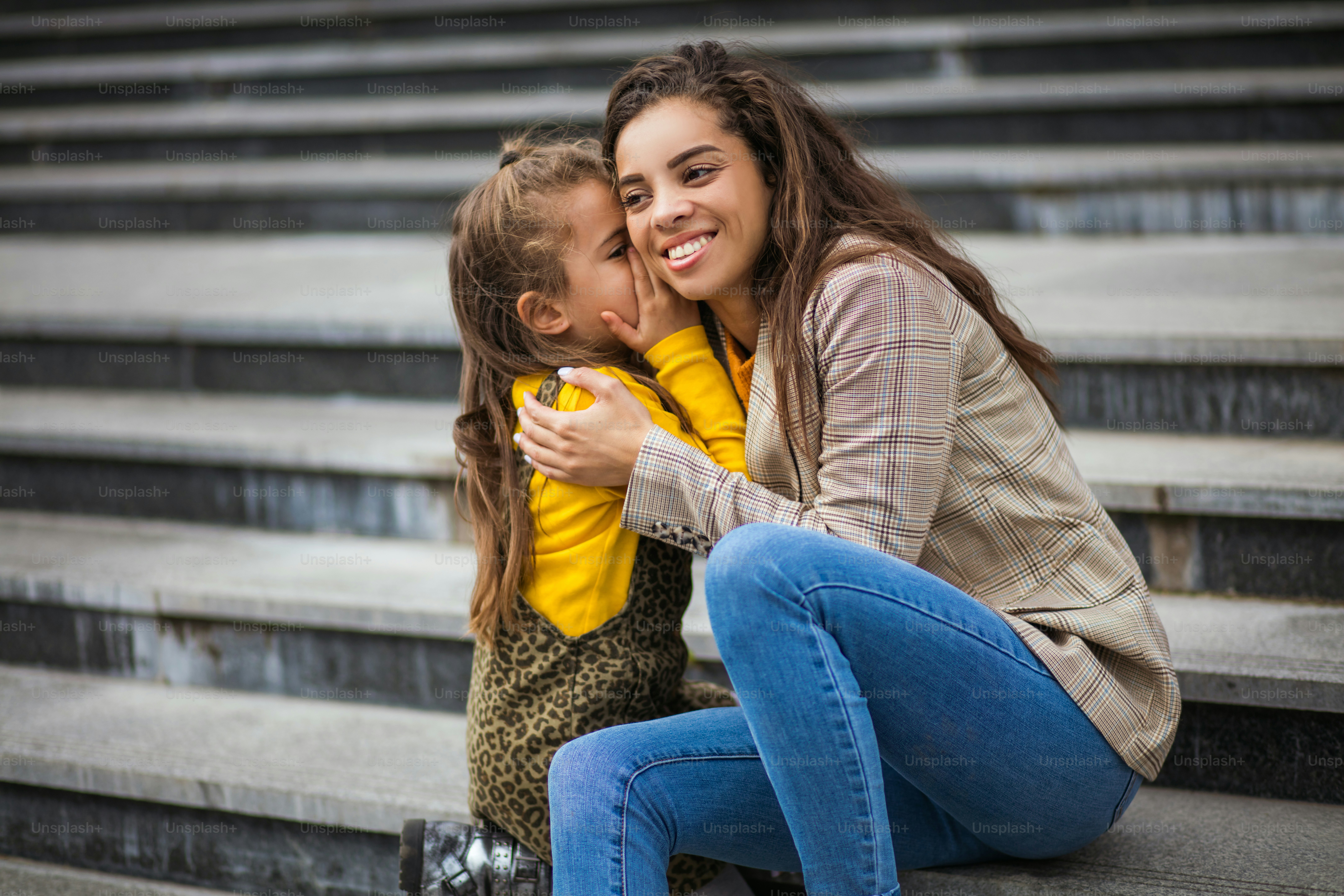 Chuchotement.  Une mère afro-américaine avec sa fille dans la ville.