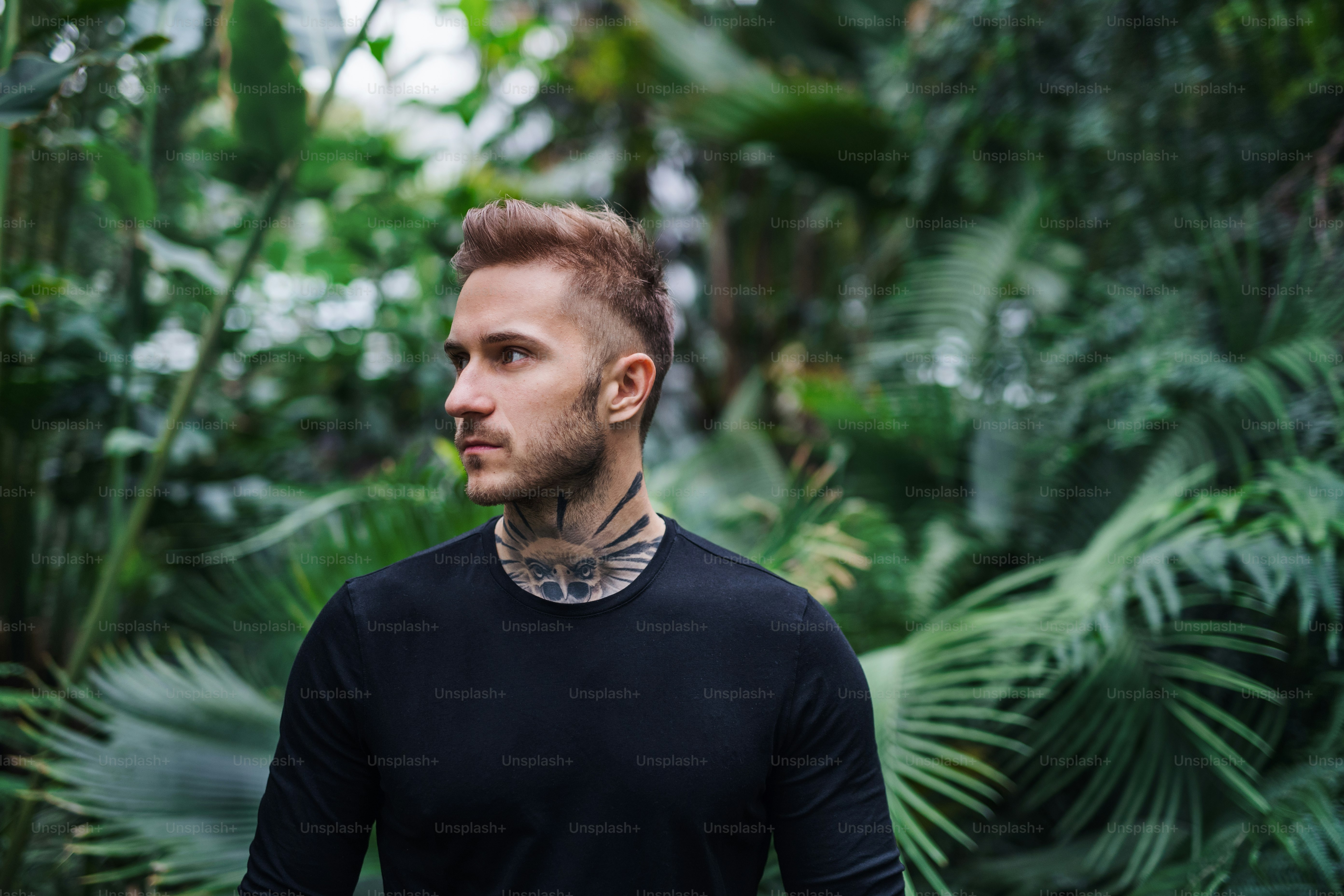 Junger Mann im botanischen Garten. Speicherplatz kopieren. Green Businessness-Konzept.