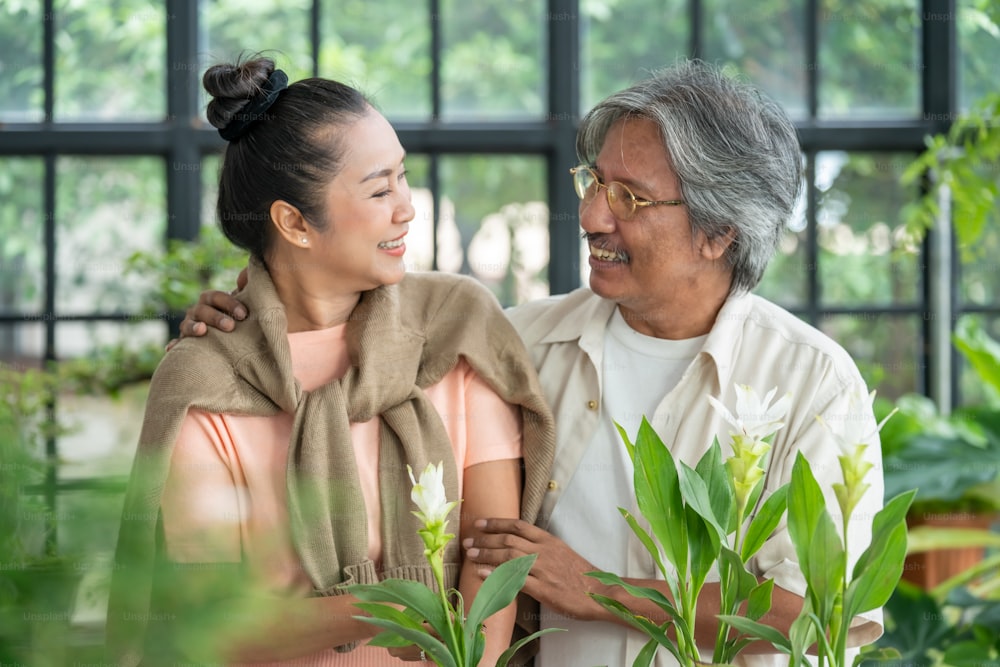 Asian senior couple enjoy romantic moment together in greenhouse garden at home