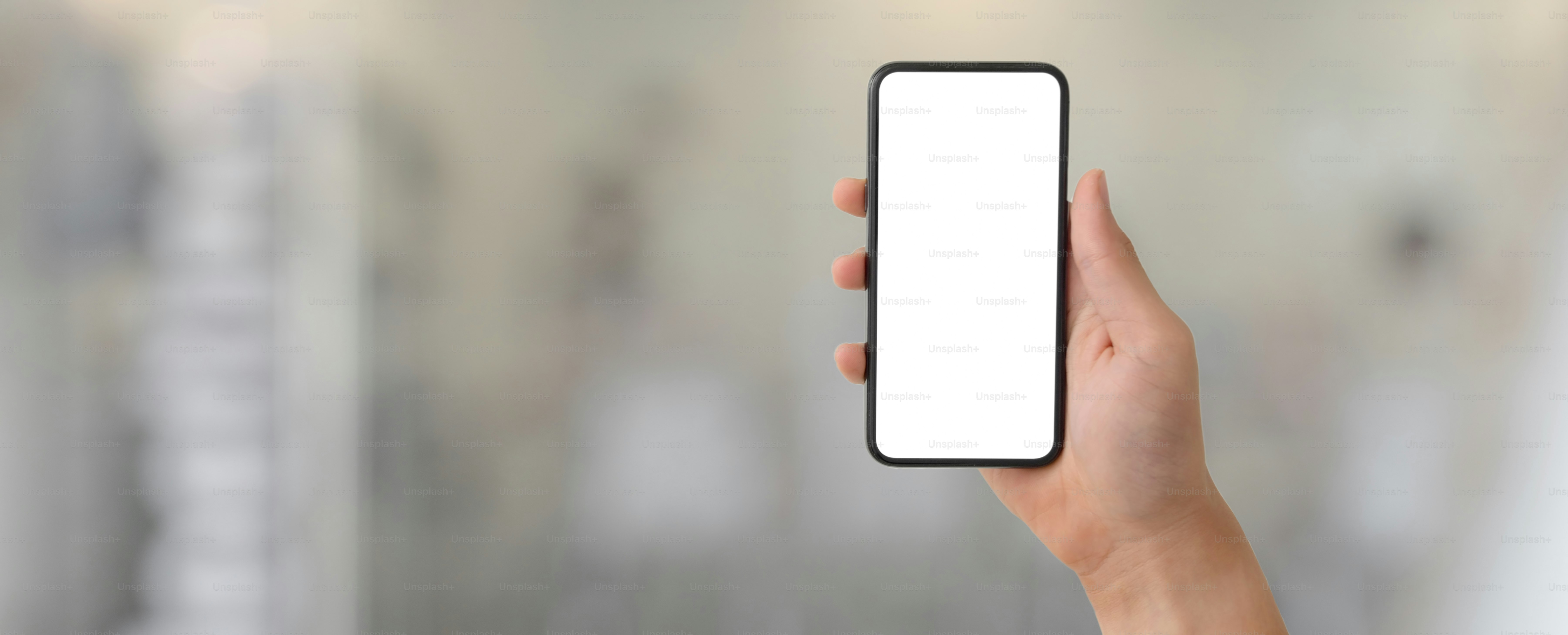Abgeschnittene Aufnahme eines Mannes mit leerem Bildschirm Smartphone in verschwommenem Glas Trennwand Büroraum Hintergrund