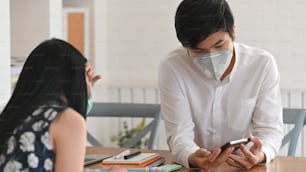 Young couple that infected a covid-19 virus(corona virus) sitting together at the wooden table while keeping a quarantine their self at home. Infected people and spread of virus concept.