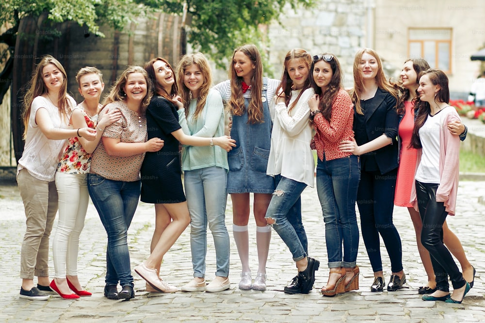 Gruppo di donne alla moda felici che si divertono sullo sfondo della vecchia strada della città europea, viaggiano o celebrano il concetto di amicizia, momenti di felicità