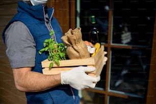 Unrecognizable courier delivering fresh fruit and vegetables groceries shopping, corona virus and quarantine concept.