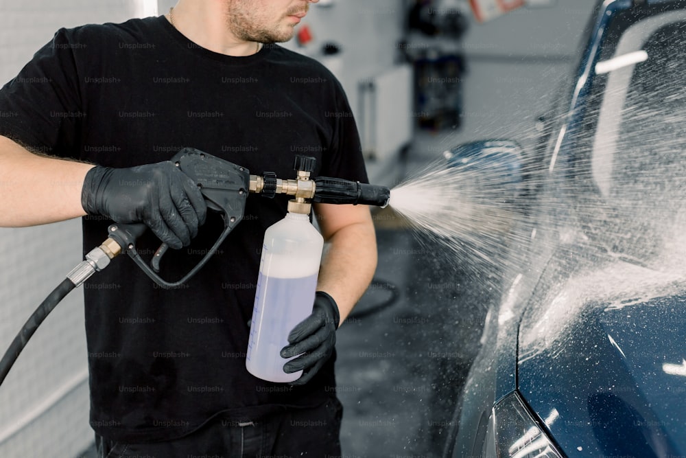Lavado de coche negro con espuma activa. El hombre lava máquina de espuma.  Car Wash lavadora en la estación Fotografía de stock - Alamy