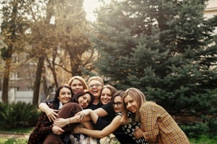 햇볕이 잘 드는 공원에서 축하 행사에서 즐거운 시간을 보내는 세련되고 우아한 여성들, 재미있는 순간 개념, 함께 모인