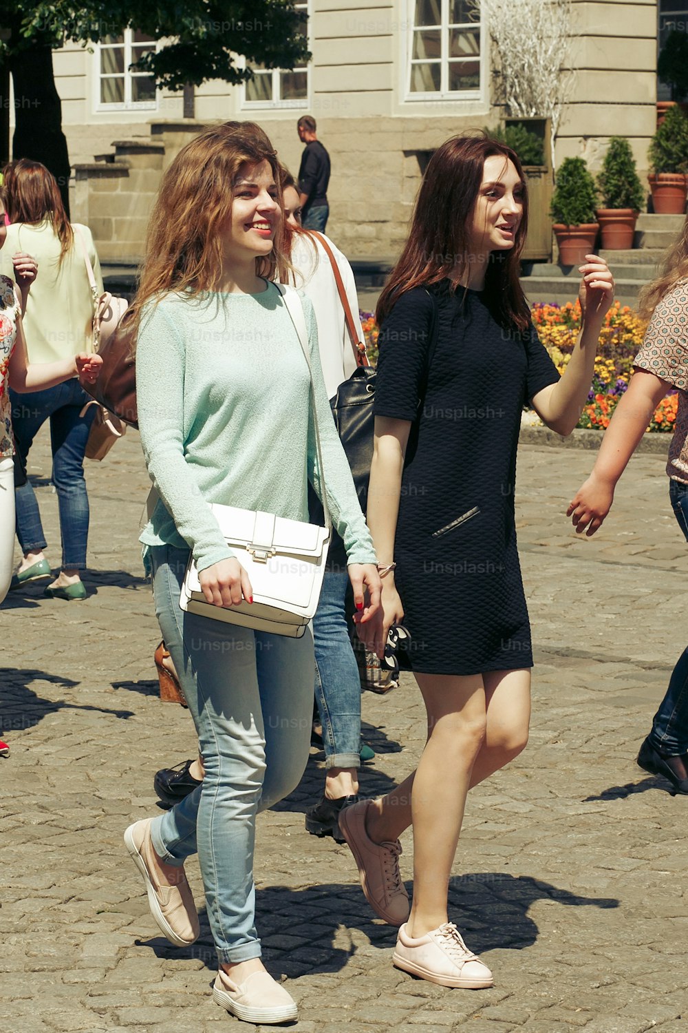 많은 젊은 행복한 여성들이 옛 유럽 도시 거리, 세련된 힙스터 소녀들이 재미, 행복의 순간, 우정 개념을 배경으로 이야기하고 있다