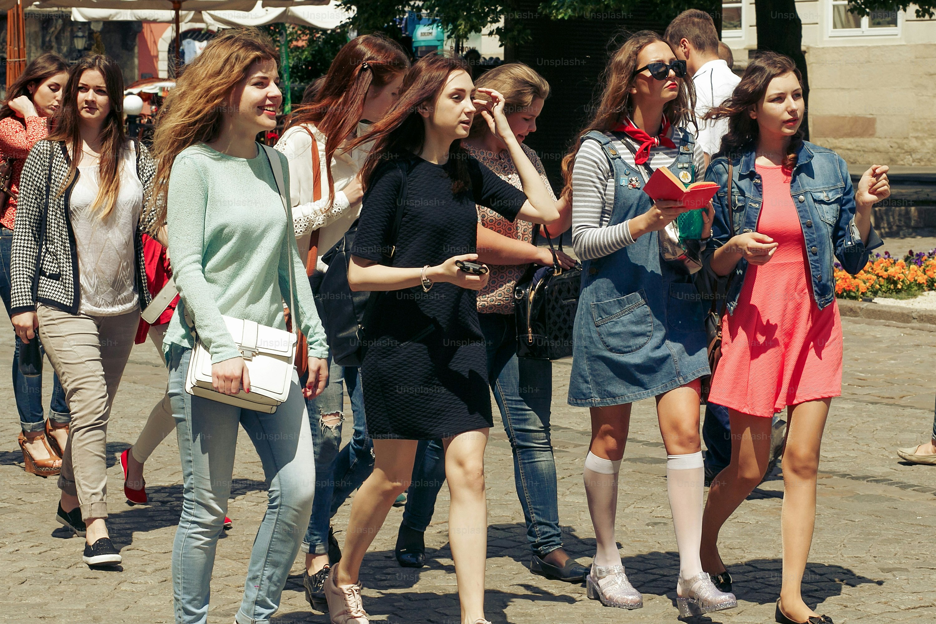 many young happy women walking talking  on background of old european city street, stylish hipster girls having fun, moments of happiness, friendship concept