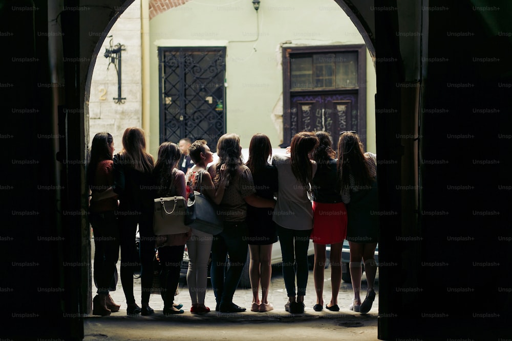 young happy women looking at old european city street, stylish hipster girls, moments of happiness, friendship concept, view from back