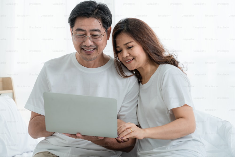 Happy Asian senior couple having good time at home. Old people retirement and healthy citizens elderly concept.