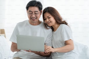 Feliz pareja de ancianos asiáticos pasando un buen rato en casa. Jubilación de personas mayores y ciudadanos sanos concepto de edad avanzada.