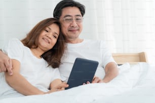 Felice coppia di anziani asiatici che si divertono a casa. Pensionamento degli anziani e concetto di anziani cittadini sani.