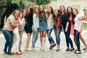 Grupo de mujeres felices con estilo que se divierten en el fondo de la vieja calle europea de la ciudad, viajan o celebran el concepto de amistad, momentos de felicidad