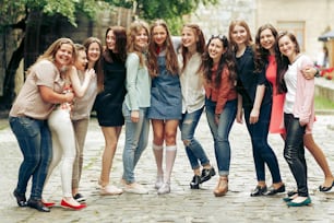 Group of happy stylish women having fun on background of old european city street, travel or celebrating friendship concept, moments of happiness