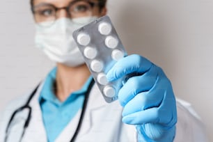 Médico feminino jovem e pílulas na embalagem da folha