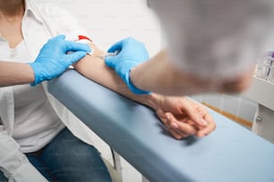Ärztliche Untersuchung. Junge Patientin besucht ihren Therapeuten, während sie eine Gesundheitsuntersuchung durchführt und Blutproben für den Test entnimmt