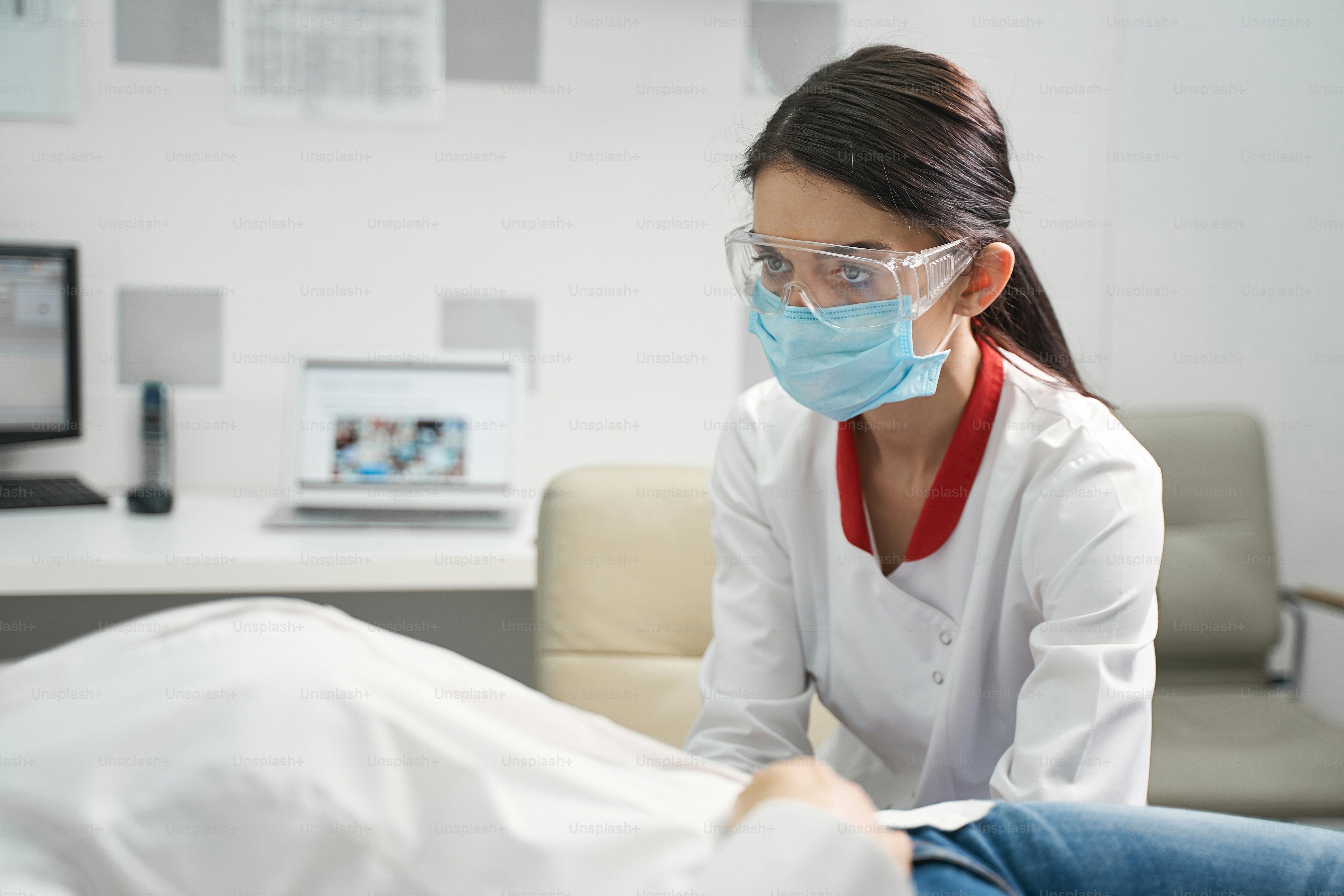 Under control. Serious brunette female person wearing medical uniform while working in modern clinic